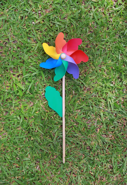 istock Colorful pinwheel over green grass. 825416380