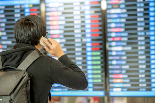 istock Young asian man with backpack bag checking his flight from the flight information board 825420210