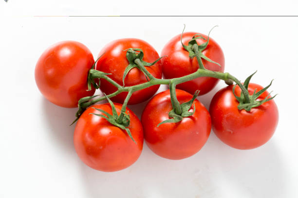 istock Bunch of fresh red tomatoes isolated on white background 825420344