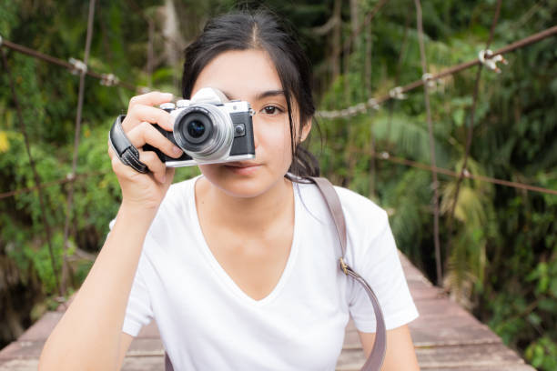 istock Asian woman taking photos outdoors in a forest 825420888