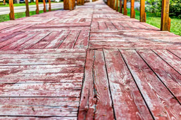 Closeup of red wooden sidewalk terrace with worn paint in vintage style