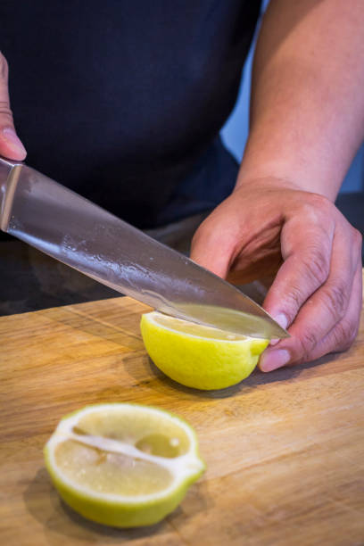 istock Chef slicing Lemon on wooden cutting board 825428752