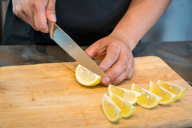 istock Chef slicing Lemon on wooden cutting board 825428890