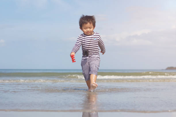 istock baby boy playing on the beach 825435736