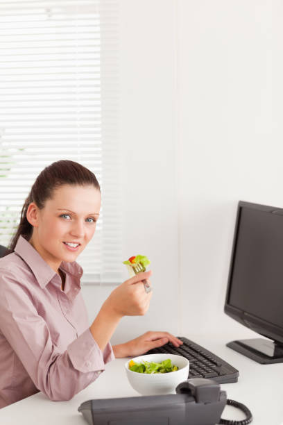 istock Businesswoman eats salad in her office 825448652