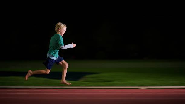 全速力で走っている少年 - sports track track and field stadium sport night ストックフォトと画像