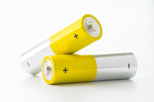 Two yellow AA size batteries isolated on white backgraound