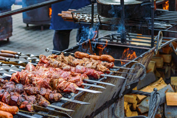 istock cooking meat and sausages on skewers 825454112