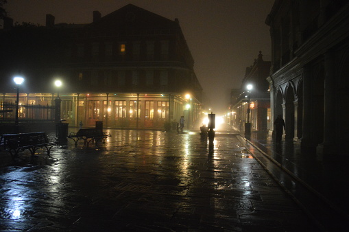 New Orleans, Louisiana - January 10, 2014:  A wet, foggy night shows reflections on streets and buildings in New Orleans, Louisiana around the historic French Quarter.