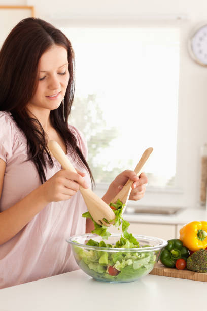 istock Smiling woman mixing a salad 825466636