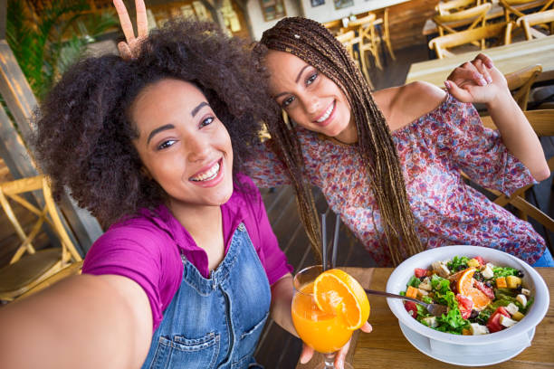 istock Girls having fun and taking selfie in acfeteria 825468664