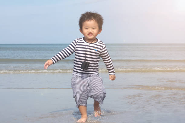 istock baby boy playing on the beach 825473122
