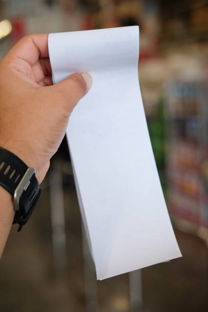 istock Hand holding paper receipt or receiving billing invoice with total expense (Supermarket shop) 825473618