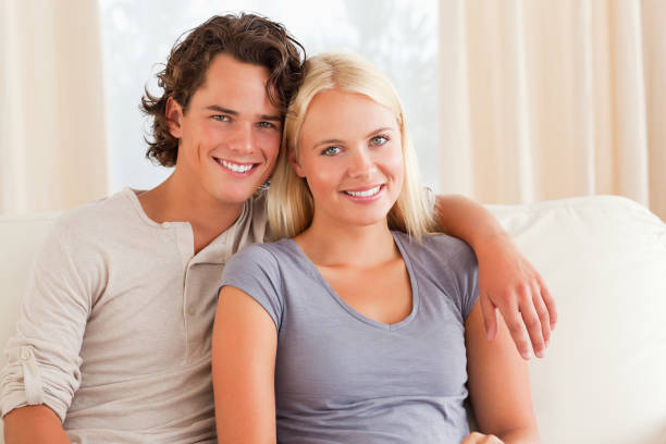 istock Young couple sitting on a couch 825474660
