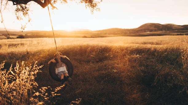 bambino su un'altalena di pneumatici - freedom tire swing tire swing foto e immagini stock