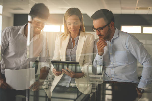 istock Business people in office having conversation and using digital tablet. 825482428