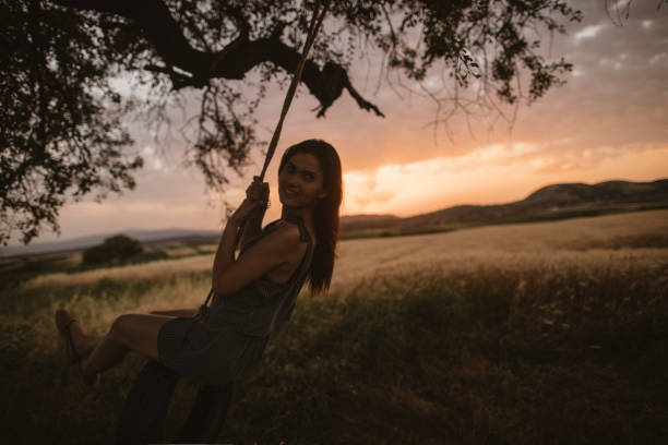 istock Young woman on a tire swing 825483034