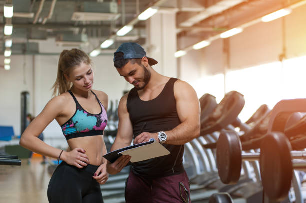 istock Woman and her personal trainer with training plan 825495368