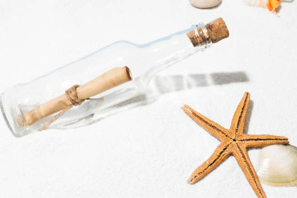 istock Message in bottle on beach with white sand,  in tropical sea 825506252