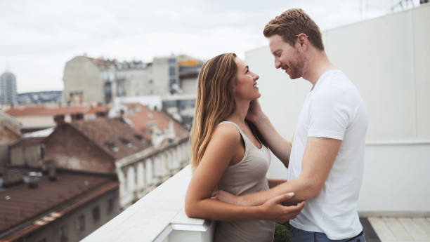 istock Romantic couple kissing on rooftop 825522452