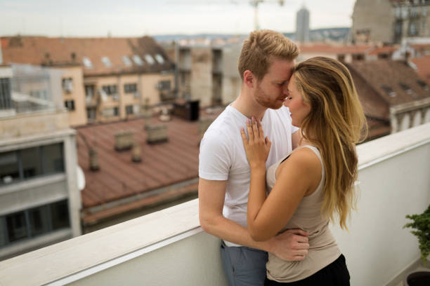 istock Romantic couple kissing on rooftop 825522468