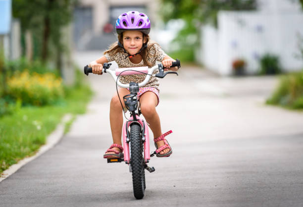 istock Children learning to drive a bicycle on a driveway outside. 825526548