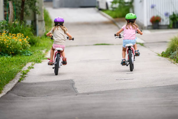 istock Children learning to drive a bicycle on a driveway outside. 825531004