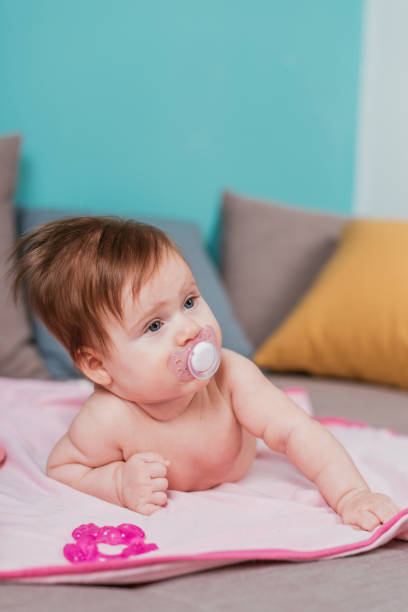 istock Cute baby girl with pacifier 825534528