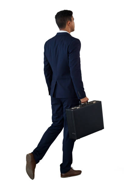 Rear view of businessman walking with briefcase against white background