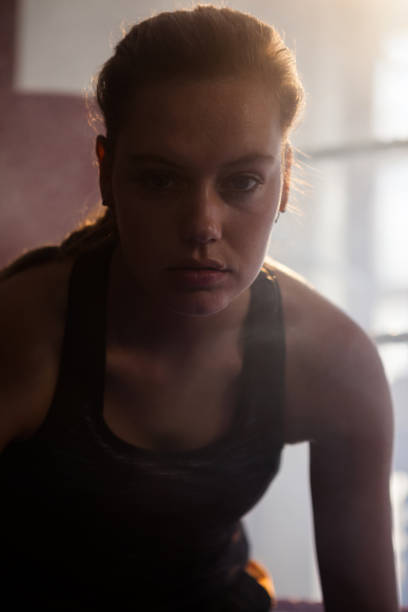 istock Confident woman sitting in boxing ring 825549486