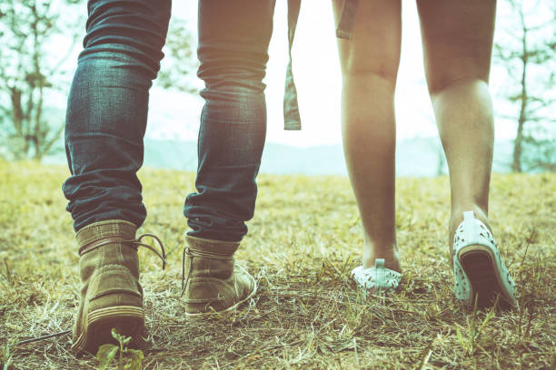 istock Men's legs with women walking together on vacation. 825549928