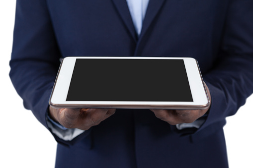 Mid section of businessman holding digital tablet