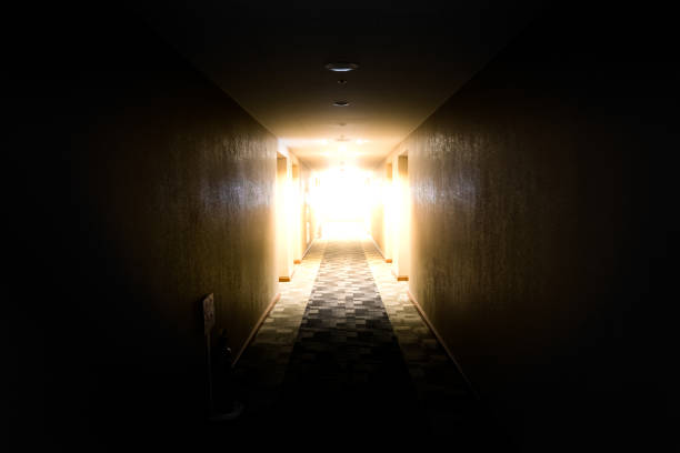istock light shining from the end of dark corridor 825550370