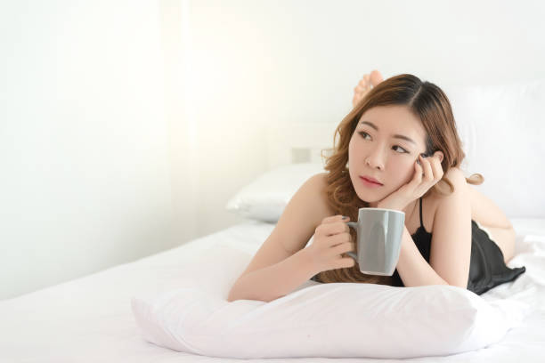 istock Slim Asian woman posing in bed 825551206