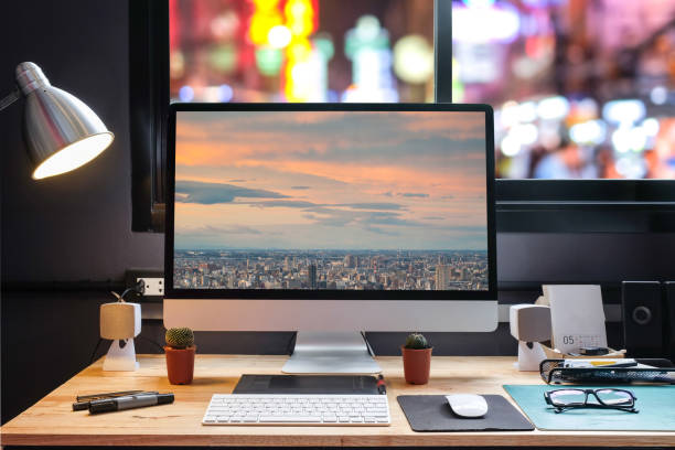 istock Graphic designer's workspace with city night view with a pen tablet, a computer and white background for text 825554548