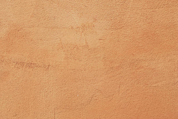 istock Closeup on Light brown painted on exterior rough stucco wall Texture Italian style Background. 825558308