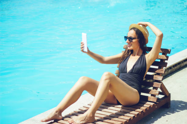 istock Woman at Pool Holding Tablet 825562286