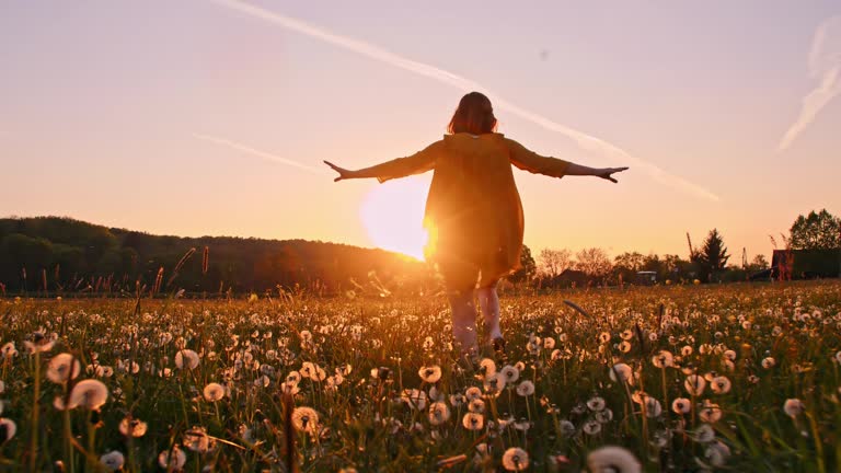 SLO MO Woman running across a meadow at sunset