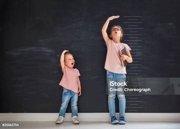 Sisters Play Together Stock Photo - Download Image Now - Growth, Child, Measuring