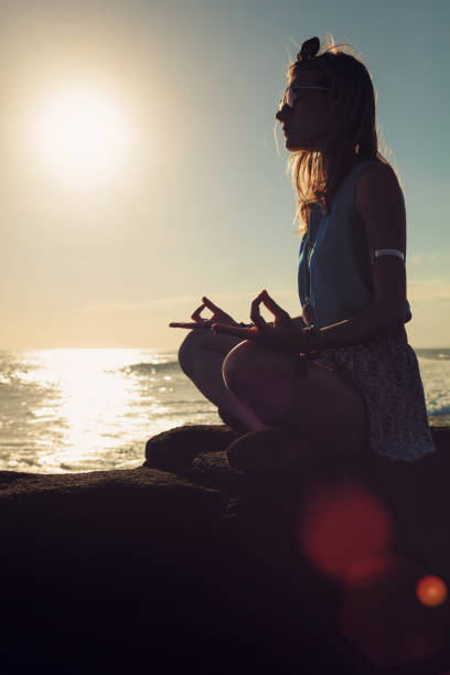 istock Woman practicing yoga on the beach. 825566548