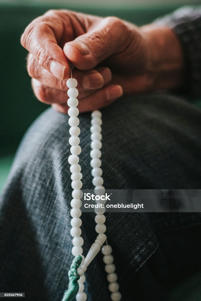 Rosary Beads Stock photo Close up on Senior Man's Hand Holding while sitting at home. This file has a signed model release. 70-79 Years Stock Photo