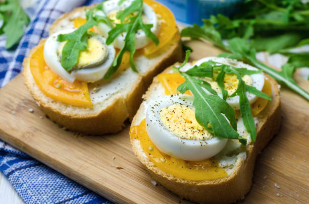 istock Sandwiches with boiled eggs, yellow tomatoes and arugula 825573080