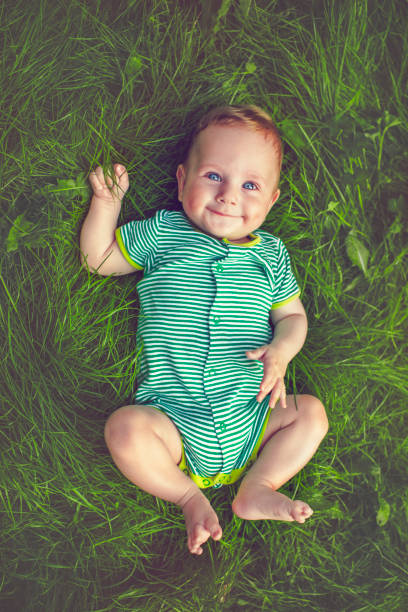 симпатичный ребенок на открытом воздухе летом - baby spring child grass стоковые фото и изображения