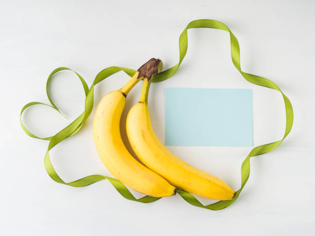 Two bananas with green ribbon frame