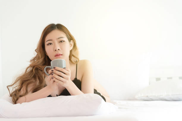 istock Slim Asian woman posing in bed 825580290