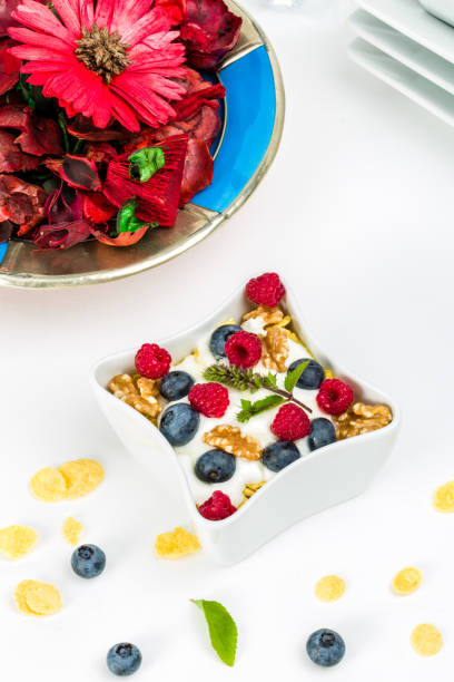 istock Corn flakes with yoghurt, honey, walnuts raspberries and blueberries 825580334