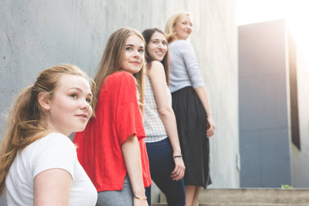 istock Young women standing on stairs by concrete wall 825586646