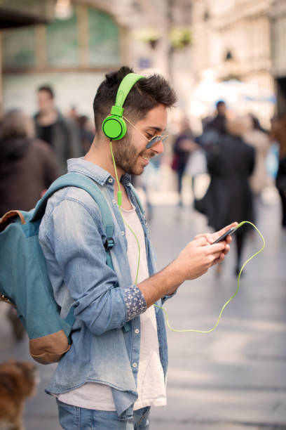 istock Smiling man texting and listening music 825592068