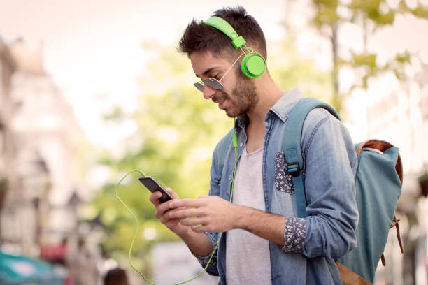 istock Smiling man texting and listening music 825592148