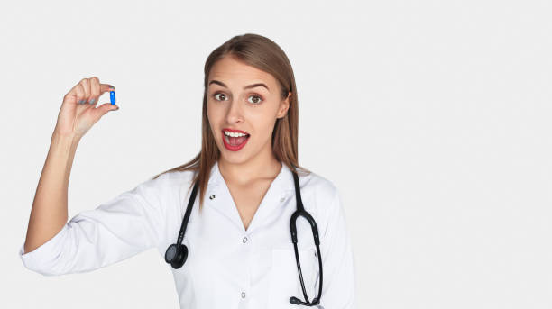 istock Female doctor with stethoscope holding blue pill 825593642